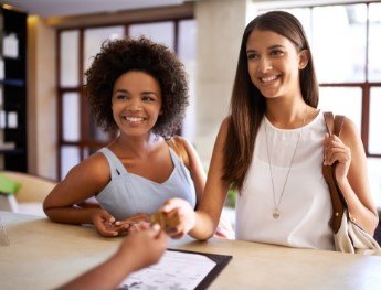 patients smiling at receptionist desk in Downers Grove